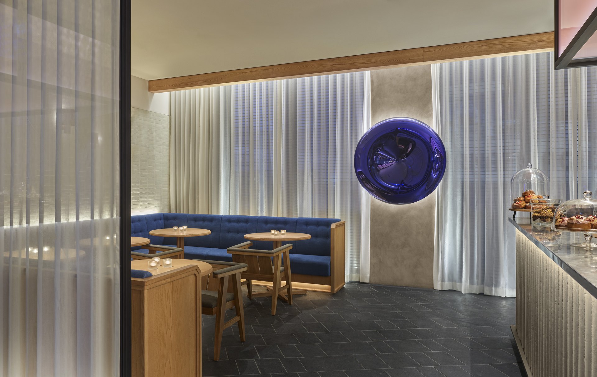 Blue banquettes and a pastry counter in the lobby lounge of The Reykjavik EDITION